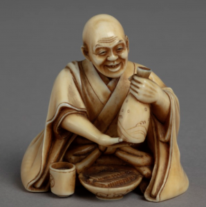 Ivory carving of seated man in kimono holding a bottle of rice wine.