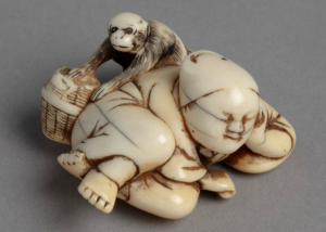 Ivory netsuke carving of a man in kimono asleep as monkey steals fruit behind his back.