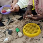 sand pit with toy archaeological tools