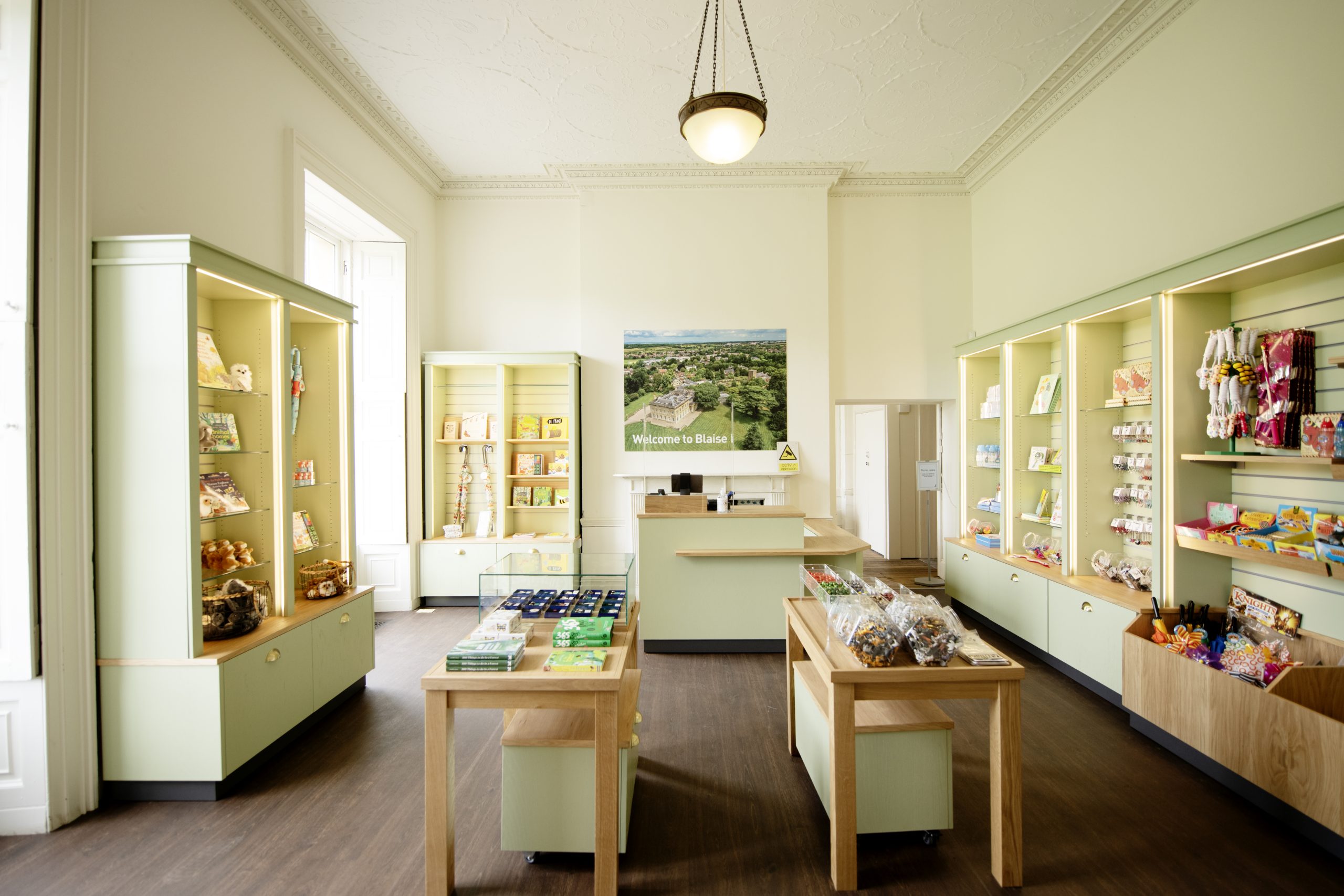 interior of a museum shop. light and airy with white walls and display cases around sides